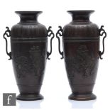 A pair of Meiji Period (1868-1912) bronze vases, each of slender ovoid form, cast in relief with