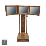 An Arts and Crafts oak triptych mirror wall bracket, the hinged mirror above a central panel
