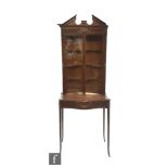 A small Edwardian mahogany Adam style display cabinet enclosed by a pair of glazed doors over a