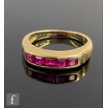 A 14ct ruby ring comprising five square cut channel set stones to plain shoulders, weight 3.9g, ring