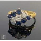 An 18ct hallmarked sapphire and diamond nine stone ring, off set alternating rows of three claw
