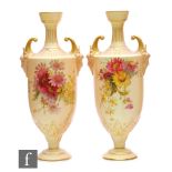 A pair of Royal Worcester blush ivory shape 1759 pedestal vases decorated with flowers with mask