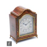 A 1930s chinoiserie mahogany cased mantle clock, engraved silvered arch dial enclosed by a glazed