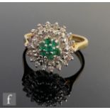An 18ct hallmarked emerald and diamond target ring, six central emeralds within a diamond border,