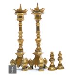 A pair of late 19th to early 20th Century ecclesiastical brass pricket candlesticks on scroll