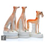 A pair of late 19th Century Staffordshire models of greyhounds, both sat with dead rabbits by