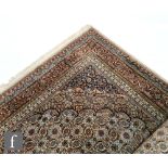 A large Persian style carpet with central medallion within running salmon pink floral border,