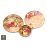 A miniature Royal Worcester Fallen Fruits cabinet trio, the interior of the cup decorated with