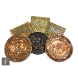 Three 19th Century pierced brass book plates, 28cm x 23cm, and three pressed copper circular wall