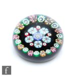 A Scottish Perthshire paperweight with a central rosette of millefiori canes within a matched border