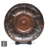 A large Arts & Crafts copper beaten shallow bowl with raised centre, diameter 42cm.