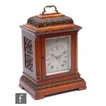 A late 19th Century carved walnut cased striking mantle clock, eight day movement, silvered engraved