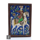 A framed Persian tile, possibly early 20th Century, hand painted with a figure on horseback