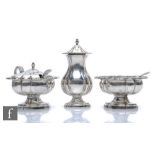 A hallmarked silver three piece pedestal cruet set of plain shaped form terminating in scroll and