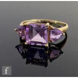 A 9ct three stone amethyst ring square cut central stone flanked by trillion cut examples, weight