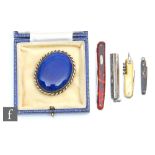 A silver combination pen and propelling pencil, three miniature fruit knives and a Ruskin brooch. (