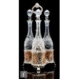A late 19th Century three bottle table decanter set, the three clear cut crystal glass bottles of