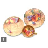 A miniature Royal Worcester Fallen Fruits cabinet trio, the interior of the cup decorated with