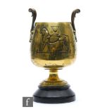 An early 20th Century bronzed two handled urn or vase carved with a stylised lion and a bull,