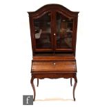 A late 19th to early 20th Century cherrywood veneered bureau bookcase, probably French, the dome
