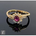 A 14ct ruby and diamond cluster ring, central oval collar set ruby within a diamond border and