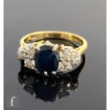 An 18ct hallmarked sapphire and diamond ring, oval central sapphire flanked by three brilliant cut