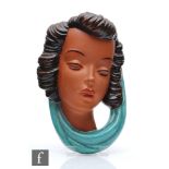 A 1950s plaster mask in the style of Goldschieder, modelled as a female head wearing a green