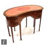 An Edwardian walnut veneered kidney shaped writing desk, with leather inset top above an arrangement