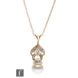 An 18ct hallmarked cultured pearl and diamond pendant with baguette cut and princess cut stones
