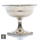 A hallmarked silver pedestal bowl square base rising to part fluted bowl with plain border weight