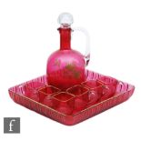 A late 19th Century ruby glass liqueur set comprising a shouldered spirit jug and six small loop