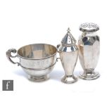 Two hallmarked silver sugar castors with a hallmarked silver twin handled pedestal bowl, total