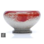 Ruskin Pottery - A small high fired footed bowl decorated in a sang de boeuf glaze against a