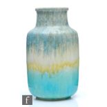 Ruskin Pottery - A vase of barrel form with a collar neck decorated in a green to yellow to blue