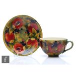 William Moorcroft - A cup and saucer decorated in the Pomegranate pattern with open and whole