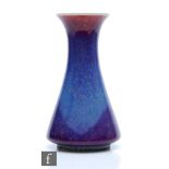 Ruskin Pottery - A high fired vase of flared form decorated in a tonal lavender with paler curtain