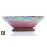 Ruskin Pottery - A large mottled pink souffle glazed bowl with painted garland to the exterior rim