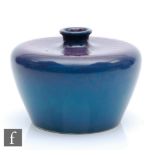 Ruskin Pottery - A small souffle glaze vase of compressed form with a flat brim neck decorated in