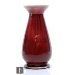Ruskin Pottery - A high fired vase of footed flared form decorated in an all over flambe glaze,
