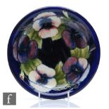 William Moorcroft - A shallow plate with a flared rim decorated in the Pansy pattern, Moorcroft