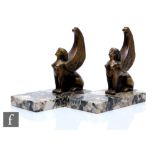 Unknown - A pair of Art Deco bookends, the polished marble bases adorned with gilt winged sphinx,