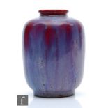 Ruskin Pottery - A small high fired vase of barrel form with a roll rim neck decorated with a
