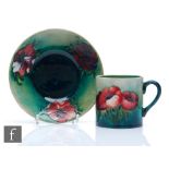 William Moorcroft - A coffee cup and saucer decorated in the Anemone pattern, Moorcroft Museum label