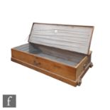 A stripped pine portable Stowaway trunk with part lift top, on wooden wheels, height 26cm x depth