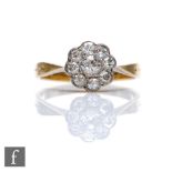 An early 20th Century 18ct diamond daisy cluster ring, nine old cut stones to knife edged shoulders,