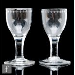 A pair of 18th Century drinking glasses circa 1770, the large round funnel bowl with upper OXO
