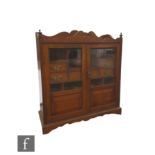 A Victorian oak smoker's cabinet fitted with drawers enclosed by a pair of glazed doors below a