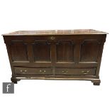 A 19th Century quadruple panel oak mule chest with conforming panel ends below a hinged top above