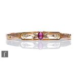 An early 20th Century 9ct rose gold expanding bracelet with a central single amethyst stone to a