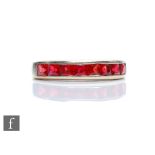 A 9ct white gold red stone half eternity ring comprising channel set square cut stones, weight 2.8g,